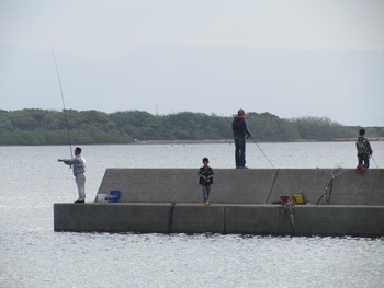 帰省客が漁港の両側で釣りを